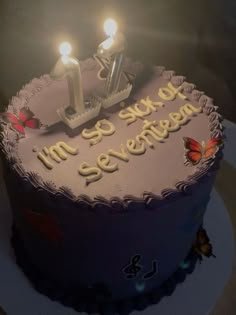 a birthday cake with two lit candles on it