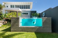 a swimming pool in front of a house with an above ground swimming pool on the side