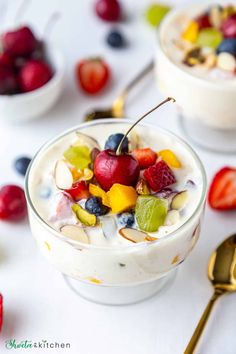 two glasses filled with fruit on top of a wooden table