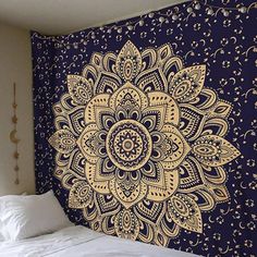 a black and gold wall hanging next to a bed with white pillows on top of it