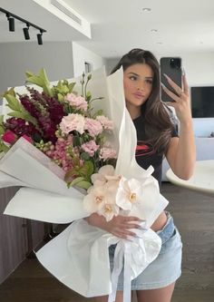 a woman taking a selfie while holding flowers