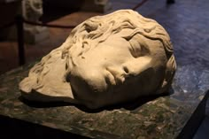 a stone head sitting on top of a table