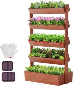 a wooden planter filled with plants next to gloves