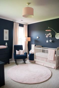 a baby's nursery room with blue walls and white rugs on the floor