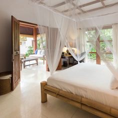 a white bed sitting in a bedroom next to a window