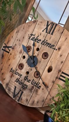 a clock made out of wooden planks with words written on the face and hands