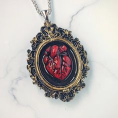 🖤 Embrace your dark elegance with my Handcrafted Realistic Heart Cameo Pendant Necklace 🖤 Indulge your Gothic sensibilities with this strikingly lifelike anatomical heart pendant, meticulously crafted by hand from rich, blood-red epoxy resin. This design features a cameo style vintage picture frame in golden color. ✨ Product Details: * Material: Each pendant is carefully handcrafted from high-quality epoxy resin, capturing the essence of a real heart with its intricate details and deep, captiv Anatomical Heart Pendant, Realistic Heart, Anatomical Heart Necklace, Real Heart, Cameo Pendant Necklace, Dark Elegance, Anatomical Heart, Vintage Picture Frames, Vintage Cameo