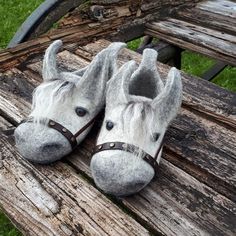 pair of slippers made to look like horses on a wooden slatted bench