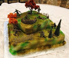 a cake that looks like an island with trees and people on it