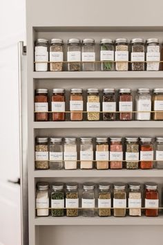 an organized spice rack in a kitchen with lots of spices and herbs on the shelves