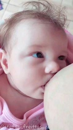 a baby is laying on the floor and chewing on something