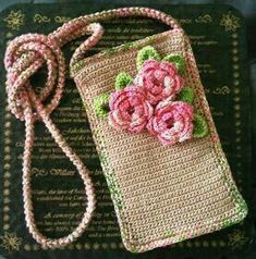 a crocheted purse with pink flowers on it