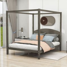 a bedroom with white walls and wood floors, has a four post bed frame in the middle