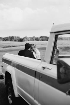 black and white photograph of bride and groom in the back of an old pickup truck