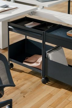 an office desk with two open drawers on wheels