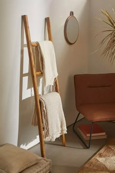 a ladder leaning up against a wall next to a chair and rug on the floor