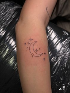 a woman's arm with a crescent and stars tattoo on it