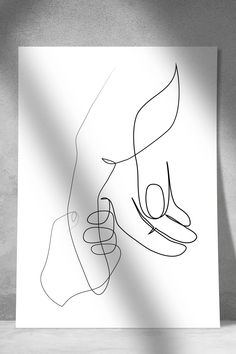 a black and white drawing of two hands holding each other's hand on a sheet of paper