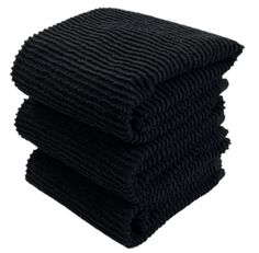 three black towels stacked on top of each other in front of a white background,