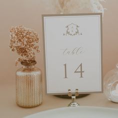 the table numbers are displayed in glass vases and jars with baby's breath flowers