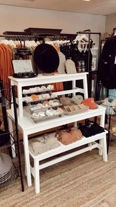 a clothing store with clothes and hats on display