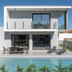 a modern house with pool and patio furniture