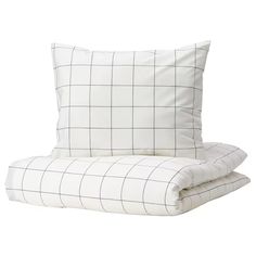 two pillows sitting next to each other on top of a white bedding set with black and white checkered sheets