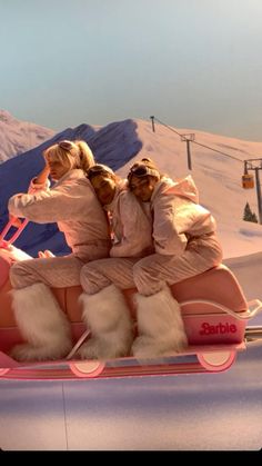 three people riding on top of a sled in the snow