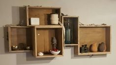 three wooden boxes with different items in them hanging on the wall next to each other