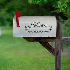 a white mailbox sitting on top of a wooden post