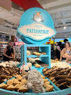 people are looking at pastries on display in a store