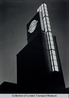 a black and white photo of a building with a clock on it's side