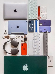 an apple laptop surrounded by assorted electronics