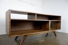 a wooden shelf sitting on top of a cement floor