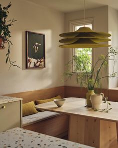 a room with a table, bench and potted plant