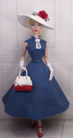 a doll wearing a blue dress and white hat