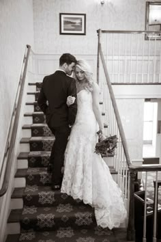 a bride and groom walking down the stairs at their wedding