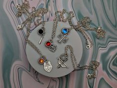 a bunch of different necklaces on a plate with some charms hanging from it's sides