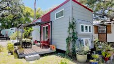 the tiny house is surrounded by trees and plants