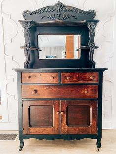 an old dresser with a mirror on top