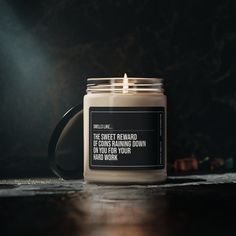 a candle sitting on top of a wooden table next to a black and white sign