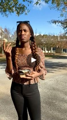 a woman standing in the street holding food