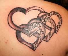 a couple of heart shaped tattoos on the back of a woman's shoulder