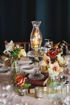 the centerpieces on this table are clear glass vases with flowers in them