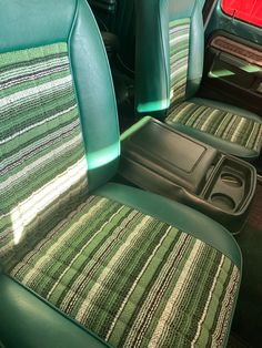 the interior of a car with green leather seats and matching carpeted floor mats on it