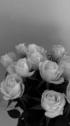 a vase filled with white roses on top of a table