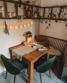 a wooden table topped with plates of food next to a green chair and wall mounted planter