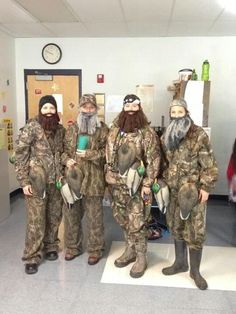 five men in duck hunting gear are posing for a photo with one man wearing camouflage