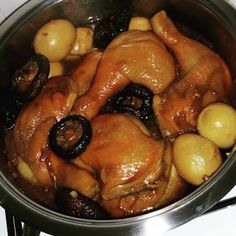 chicken and potatoes cooking in a pot on the stove