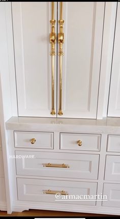 a white cabinet with gold handles and drawers